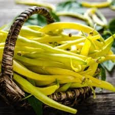 A wicker basket filled with yellow wax beans.