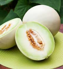 Whole and halved honeydew melons with pale green flesh and tan seeds — from BlackOwnedSeeds.com.
