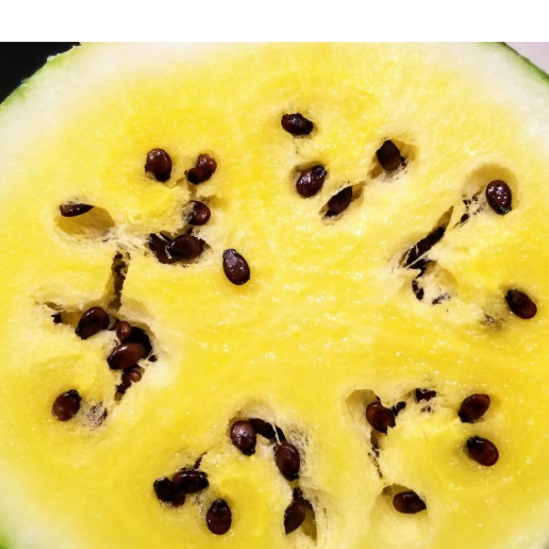 A close-up of yellow watermelon flesh with dark seeds.