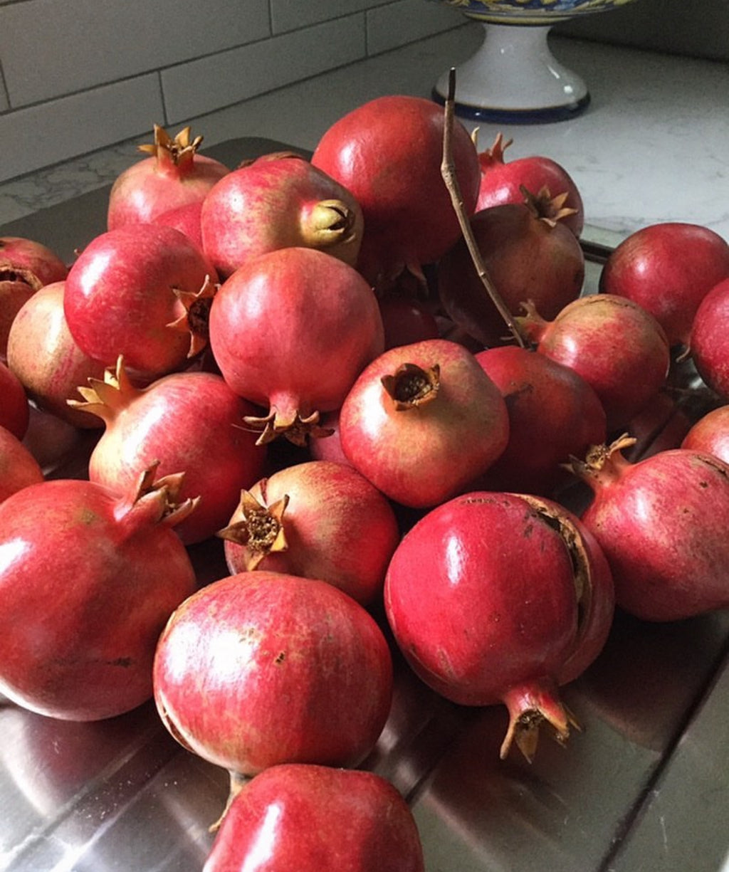 A pile of ripe red pomegranates.