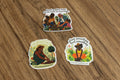 Three stickers with illustrations of people gardening and text on a brown background